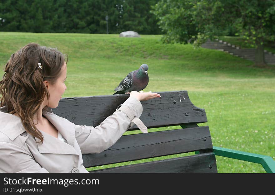 The nice girl feeds wild pigeons from a hand