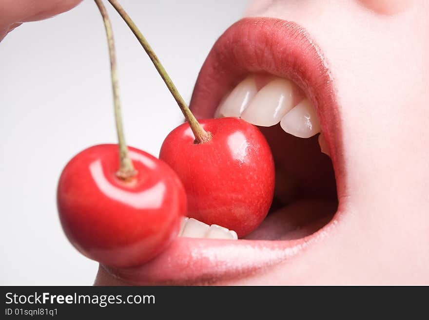 Healthy young woman eating red cherries