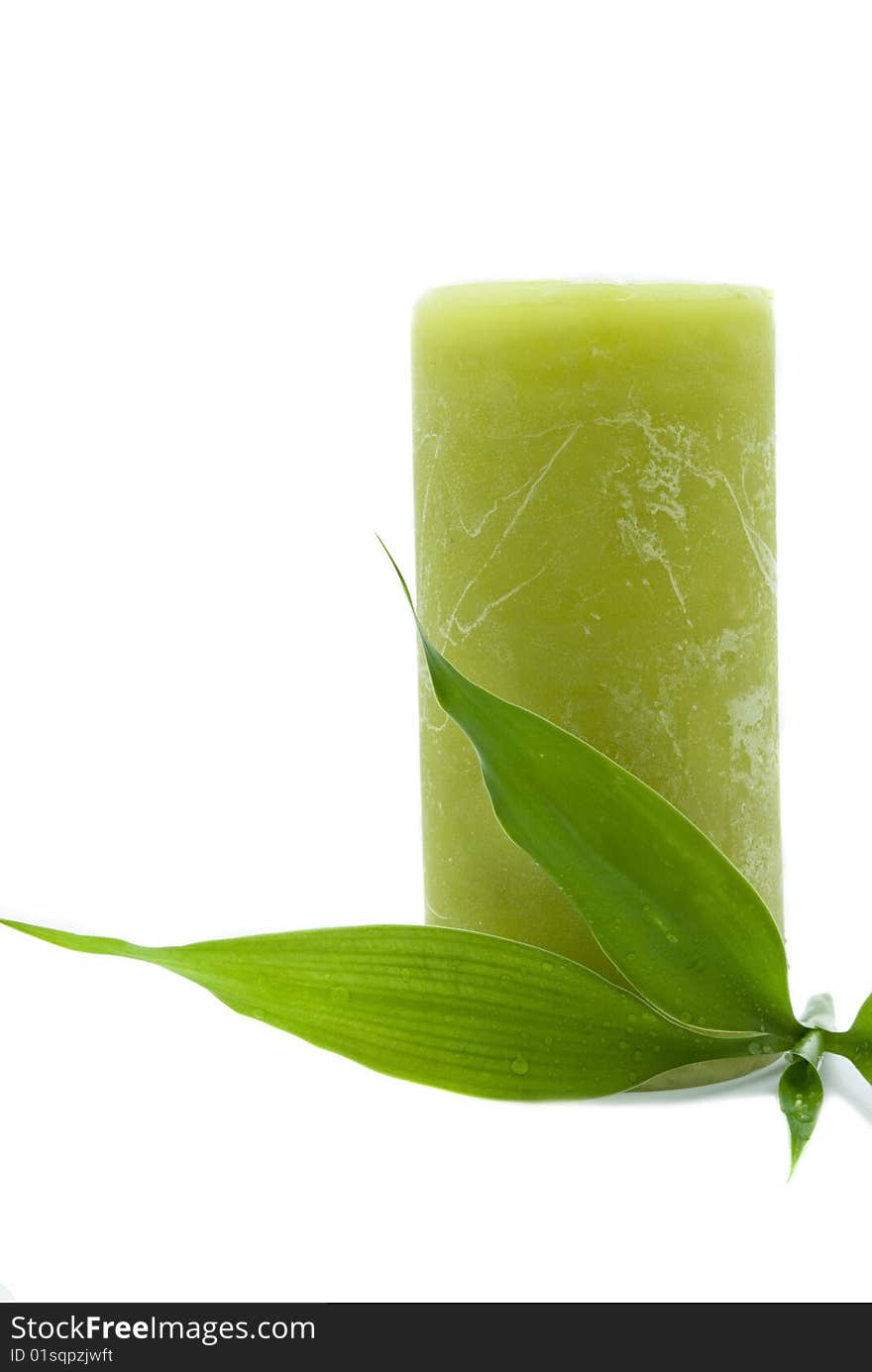 Green candle with bamboo leaf isoalted on white