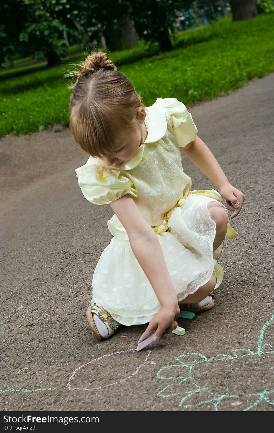 Girl drawing with a crayoun on asphalt. Girl drawing with a crayoun on asphalt