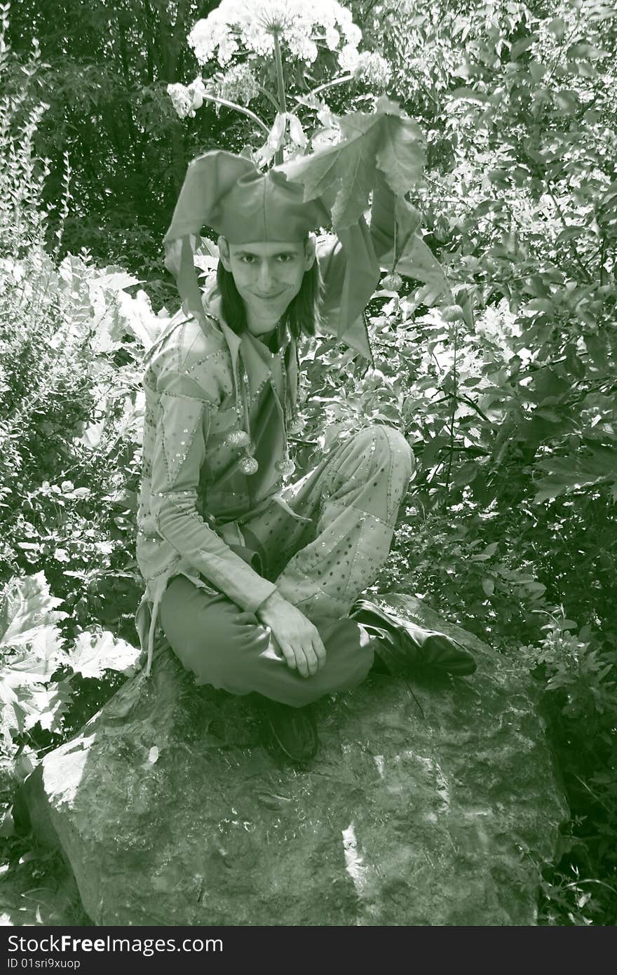 Man dressed in a clown`costume sitting outdoor. Man dressed in a clown`costume sitting outdoor