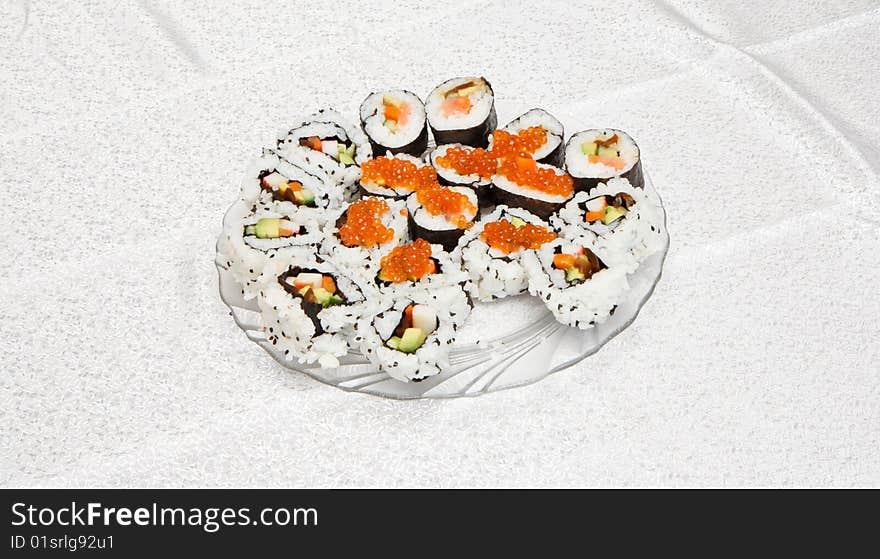 Homemade sushi of several types with red caviar on glass plate. Homemade sushi of several types with red caviar on glass plate