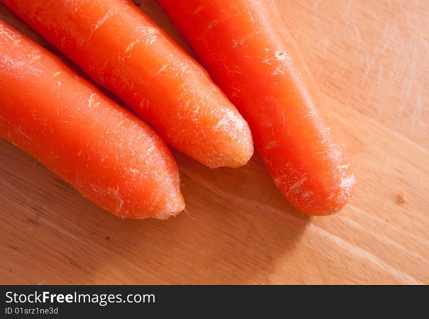 An image of carrots on a wooden chopping board. An image of carrots on a wooden chopping board