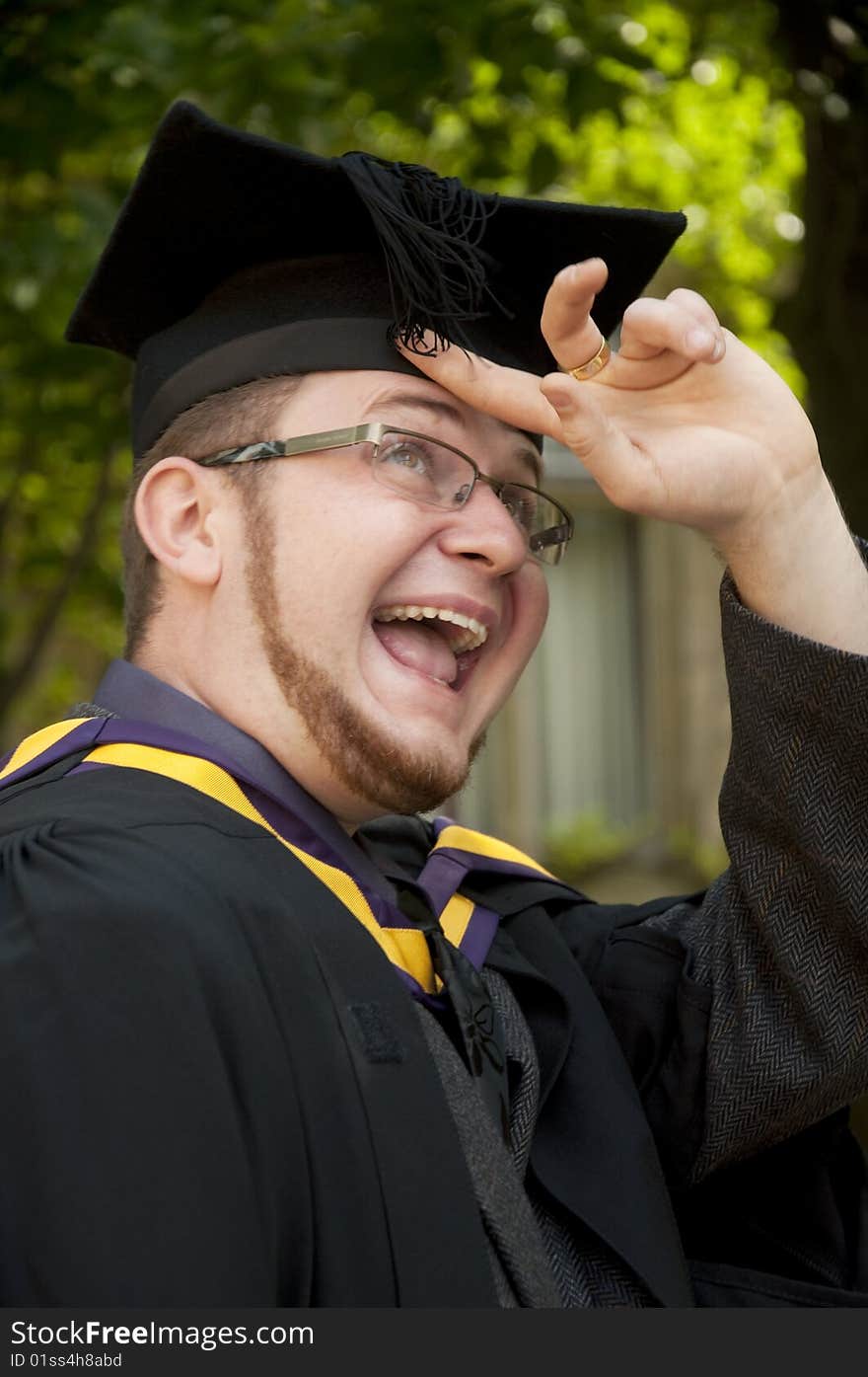 Funny graduate looks on his cap's tassel