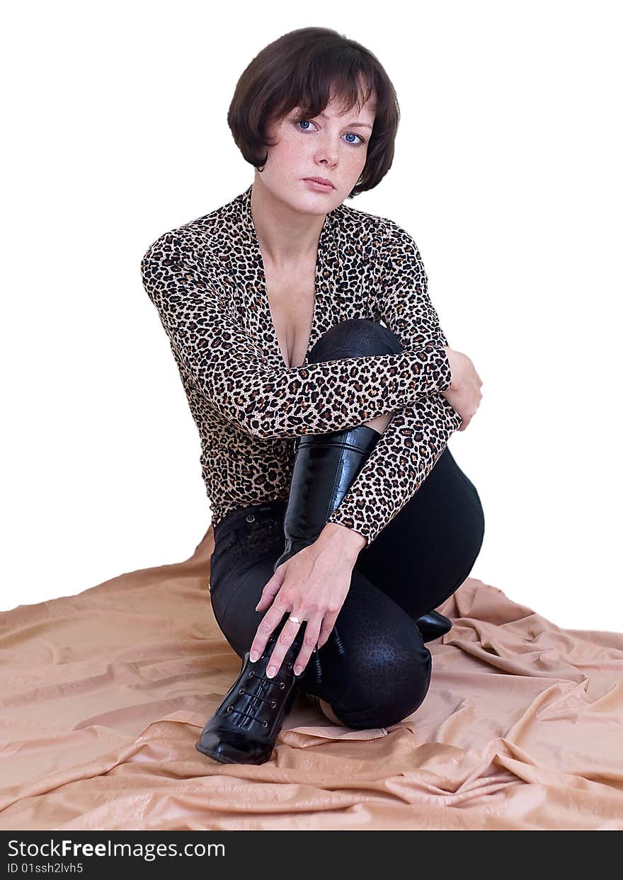 The beauty girl sit down on the floor in leopard skin blouse and black trousers and footwear. The beauty girl sit down on the floor in leopard skin blouse and black trousers and footwear