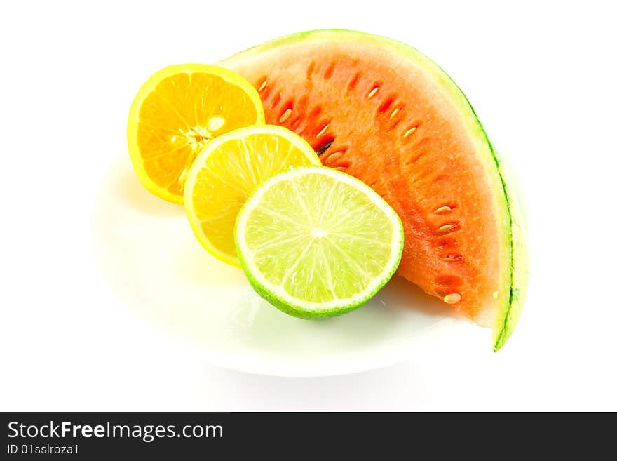 Slice of juicy watermelon with lemon, lime and orange halves on a white background