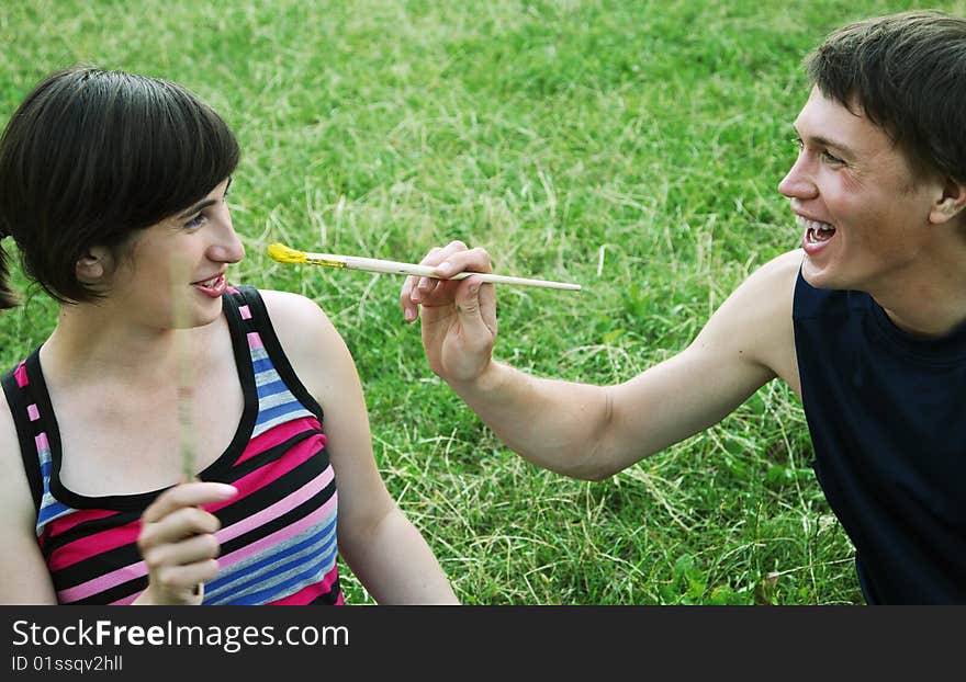 Young man and the woman draw on an open-air. Young man and the woman draw on an open-air