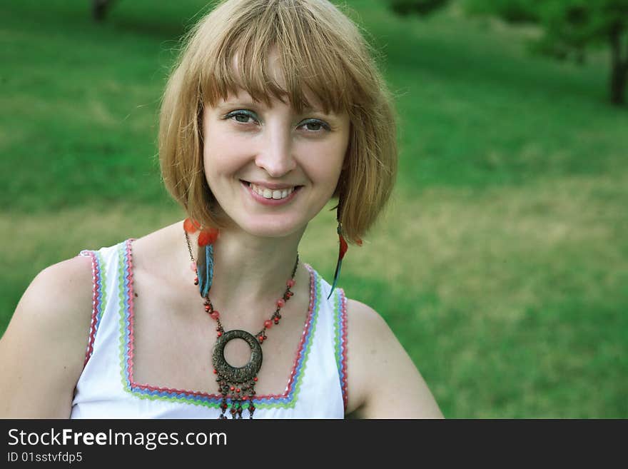 The beautiful happy blonde against a green grass