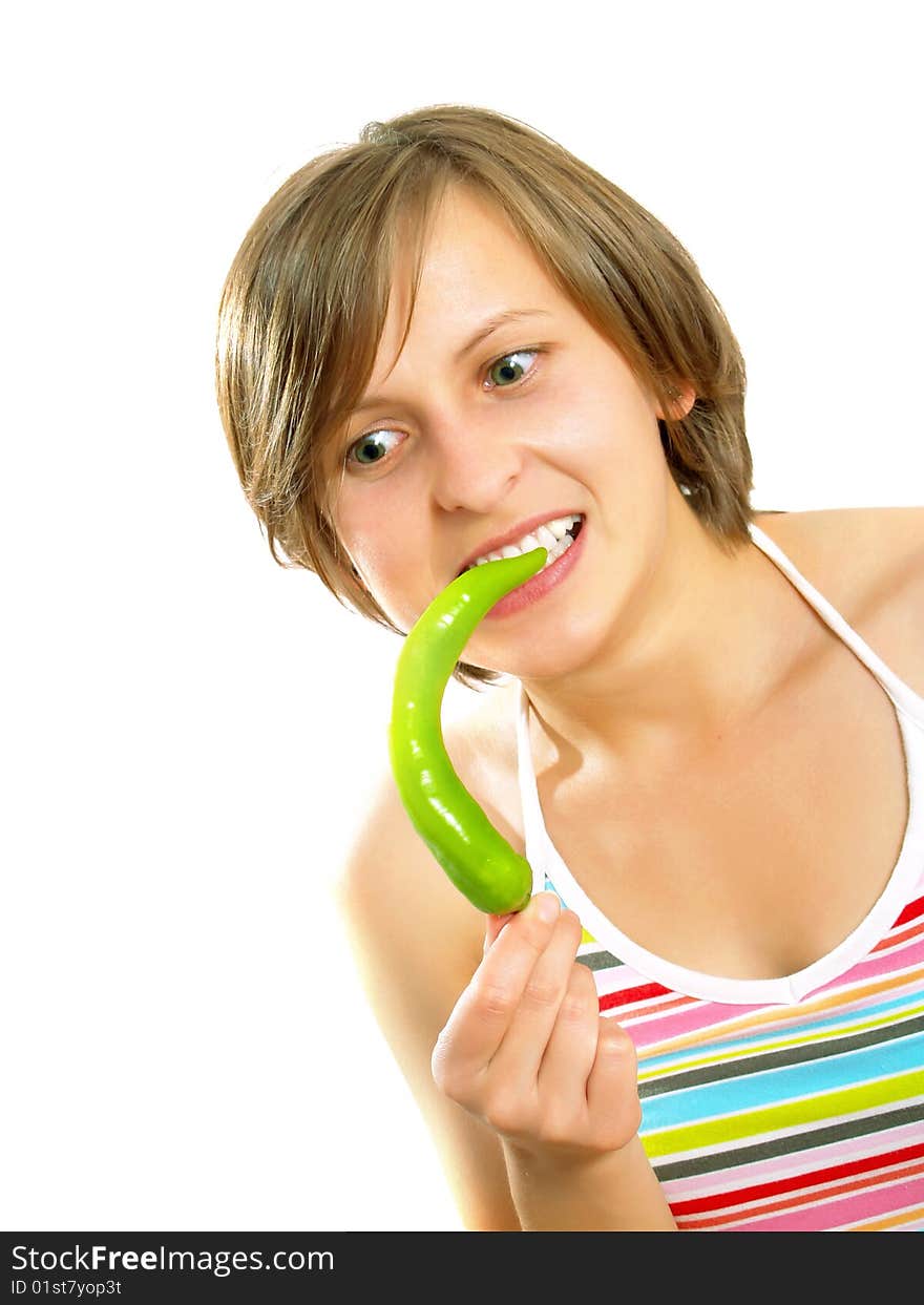 Portrait of a young cute Caucasian blond girl with a nice colorful striped summer dress who is going crazy and she is holding a fresh green chilly pepper in her hand. Isolated on white. Portrait of a young cute Caucasian blond girl with a nice colorful striped summer dress who is going crazy and she is holding a fresh green chilly pepper in her hand. Isolated on white.