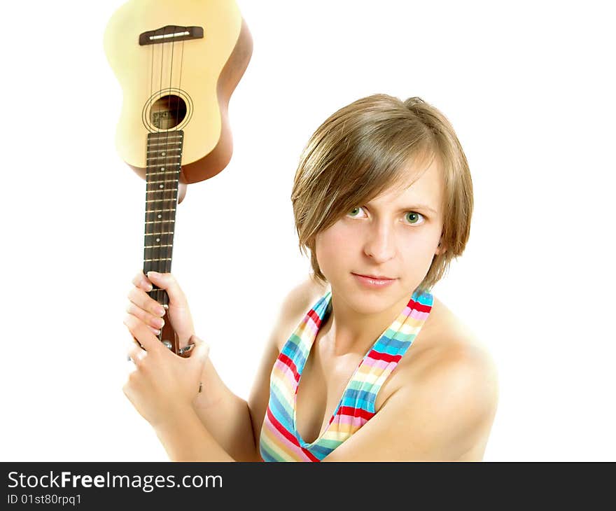 Portrait of a cute Caucasian blond girl with a nice colorful striped summer dress who is angry and she want to fight with an ukulele (small Hawaiian guitar). Isolated on white. Portrait of a cute Caucasian blond girl with a nice colorful striped summer dress who is angry and she want to fight with an ukulele (small Hawaiian guitar). Isolated on white.