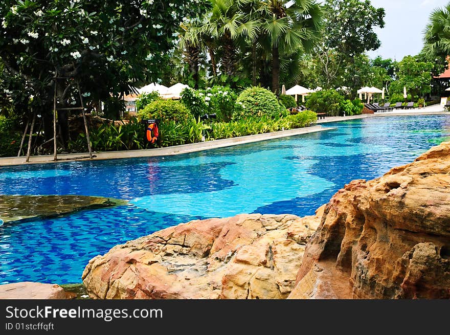 Sunbeds and umbrellas near resort's pool. Sunbeds and umbrellas near resort's pool