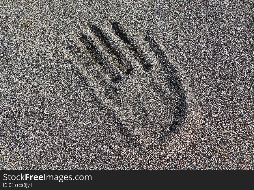 Hand print in black sand with crashed seashells. Seltjarnarnes beach, Iceland. Hand print in black sand with crashed seashells. Seltjarnarnes beach, Iceland.