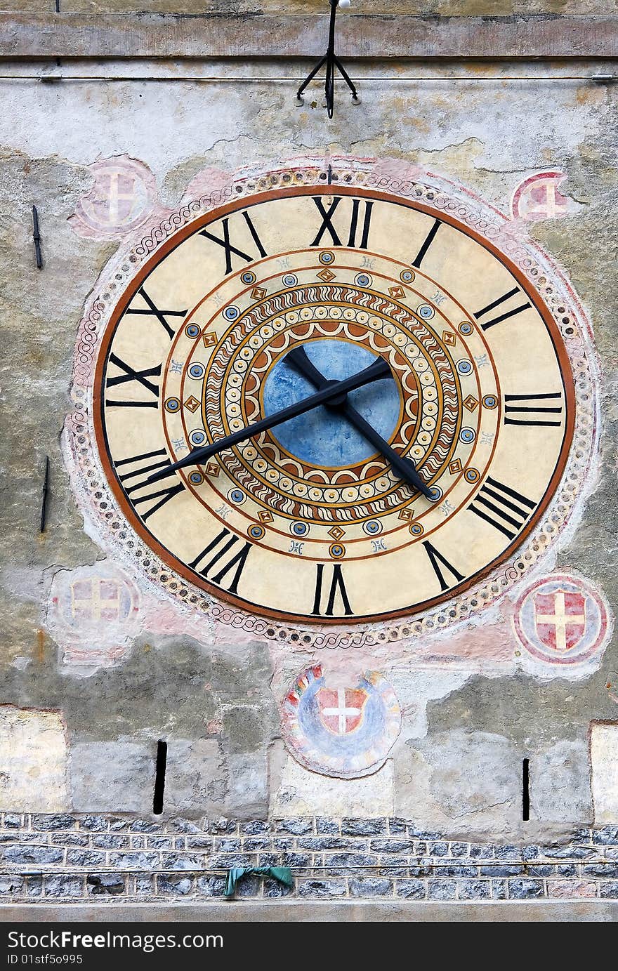 Clock with badges on an old tower