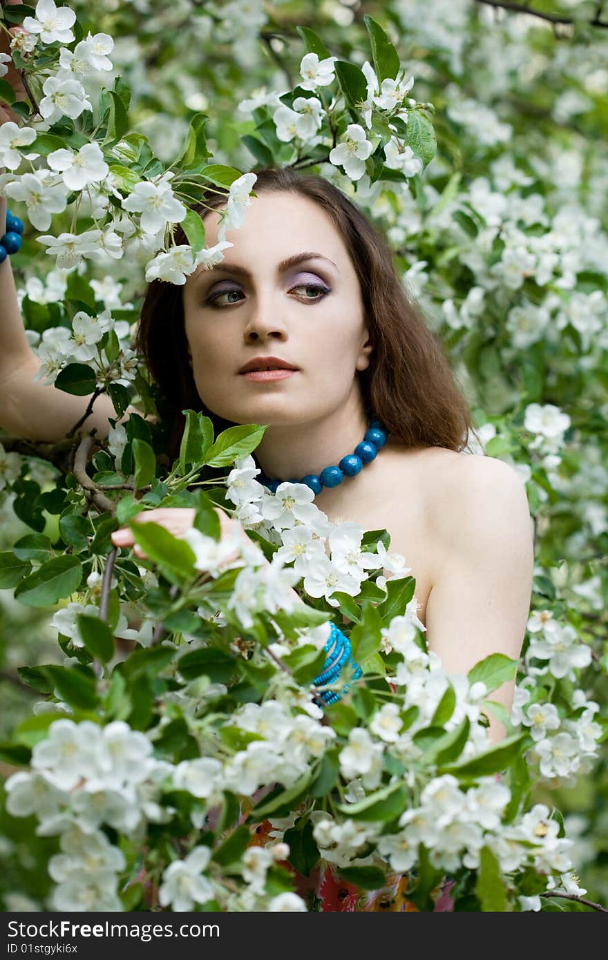 Tender girl in the garden with flowerings trees