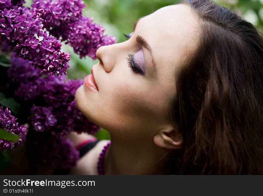 Tender girl in the garden with lilac