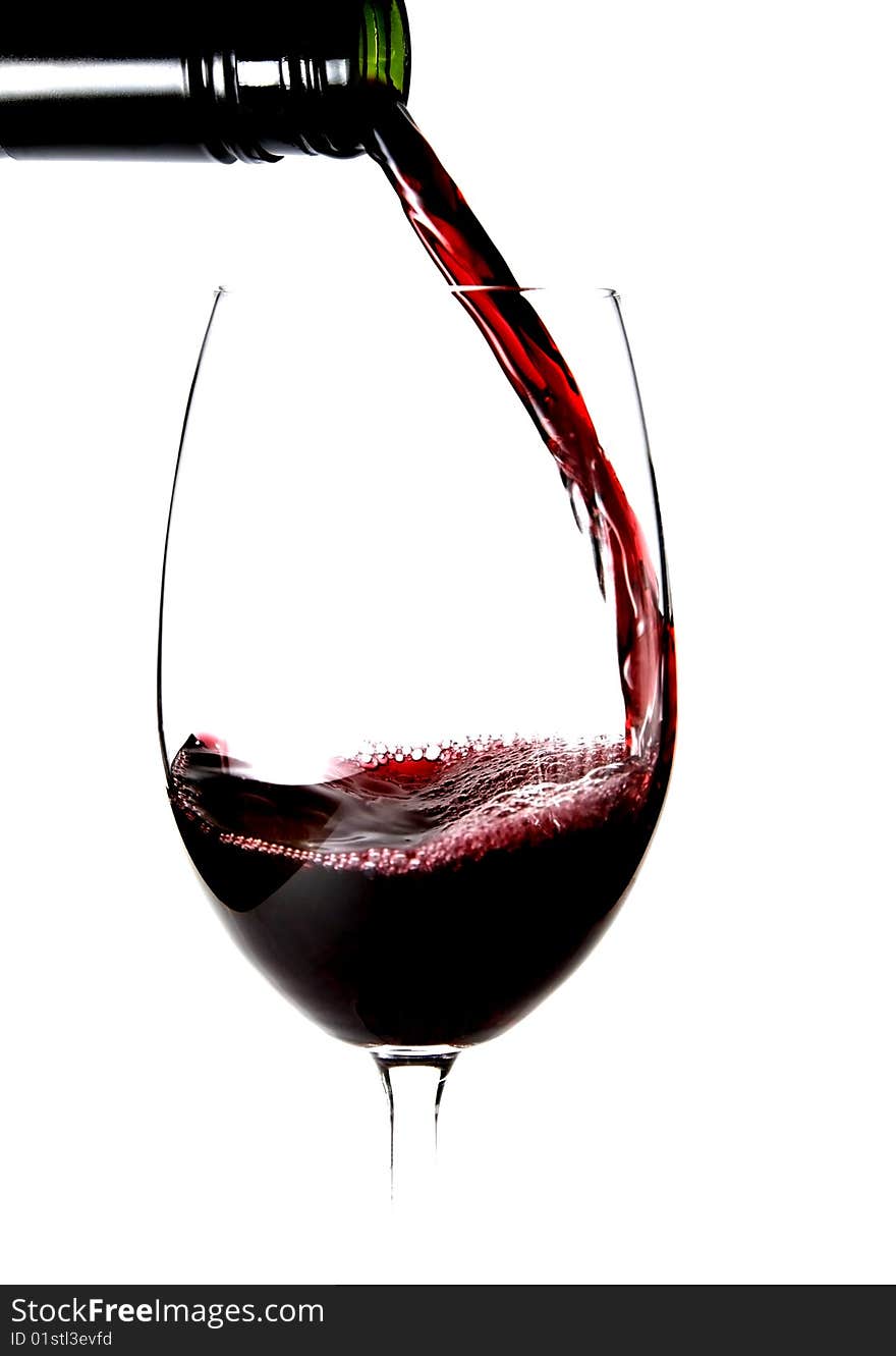 Close up shot of a bottle of red wine being poured into a glass. Close up shot of a bottle of red wine being poured into a glass