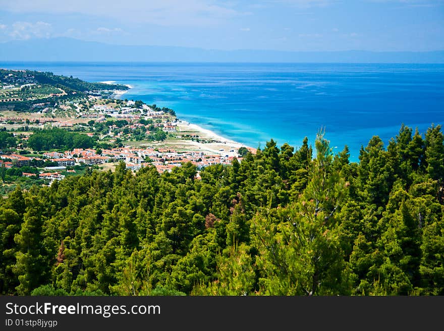 Marine landscape. Greece, Kassandra. Blue sea and sky, small towns with red roofs.