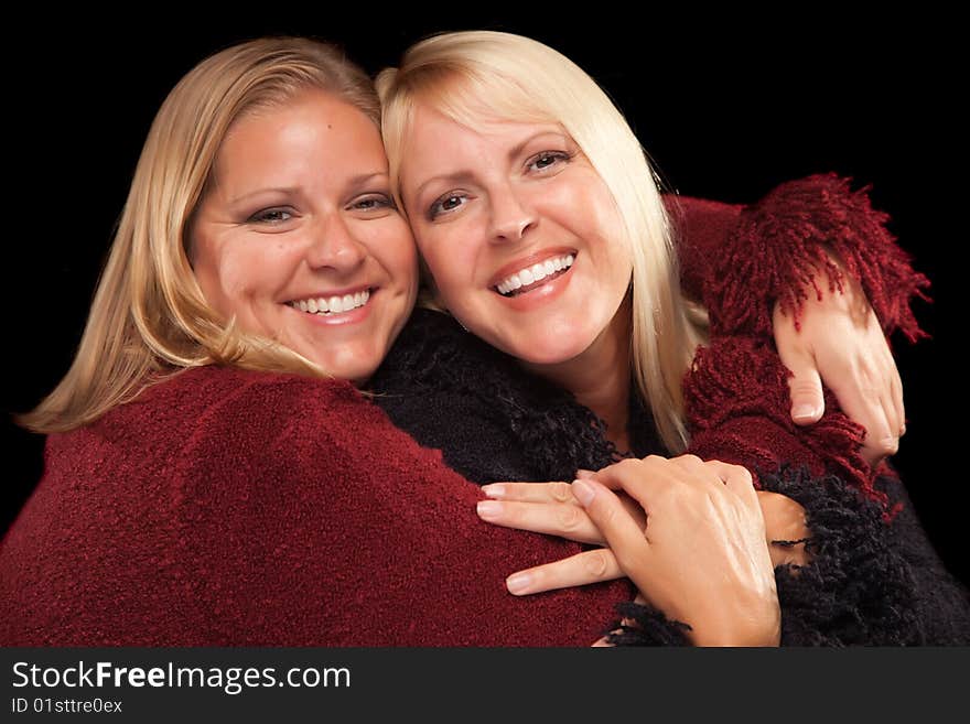 Two Beautiful Smiling Sisters Portrait Isolated on a Black Background.