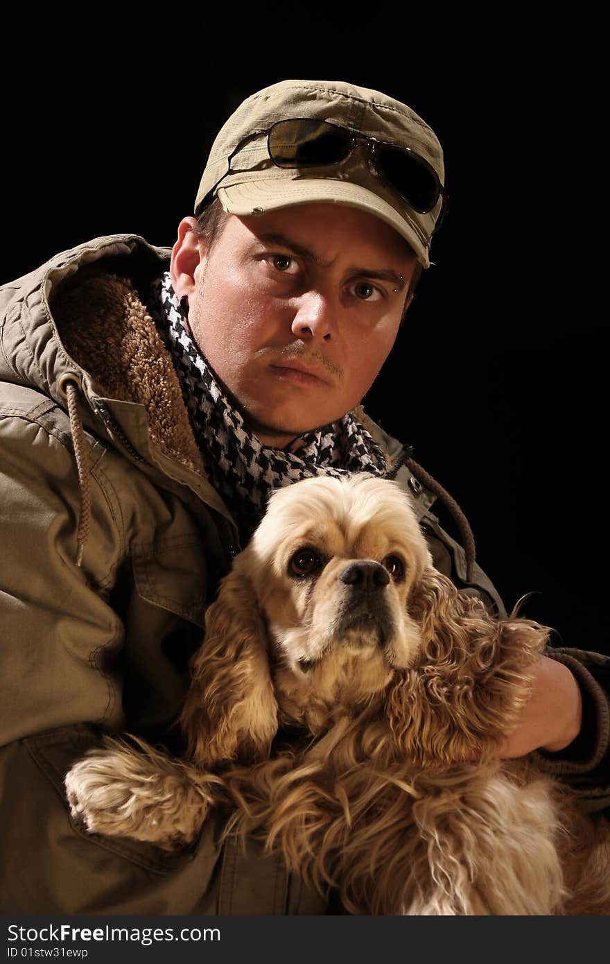 Beauty fashion male and american cocker over a black background