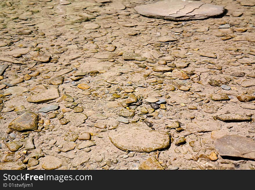 Rocks on the bottom of a shallow river, running through the mountains. Rocks on the bottom of a shallow river, running through the mountains