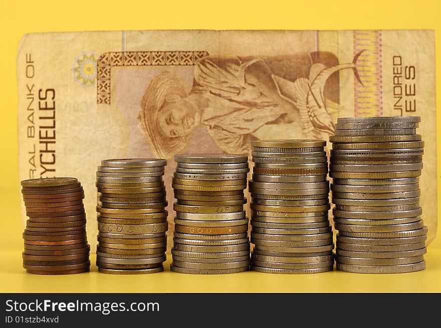 Foreign Coins And Notes On A Yellow Background