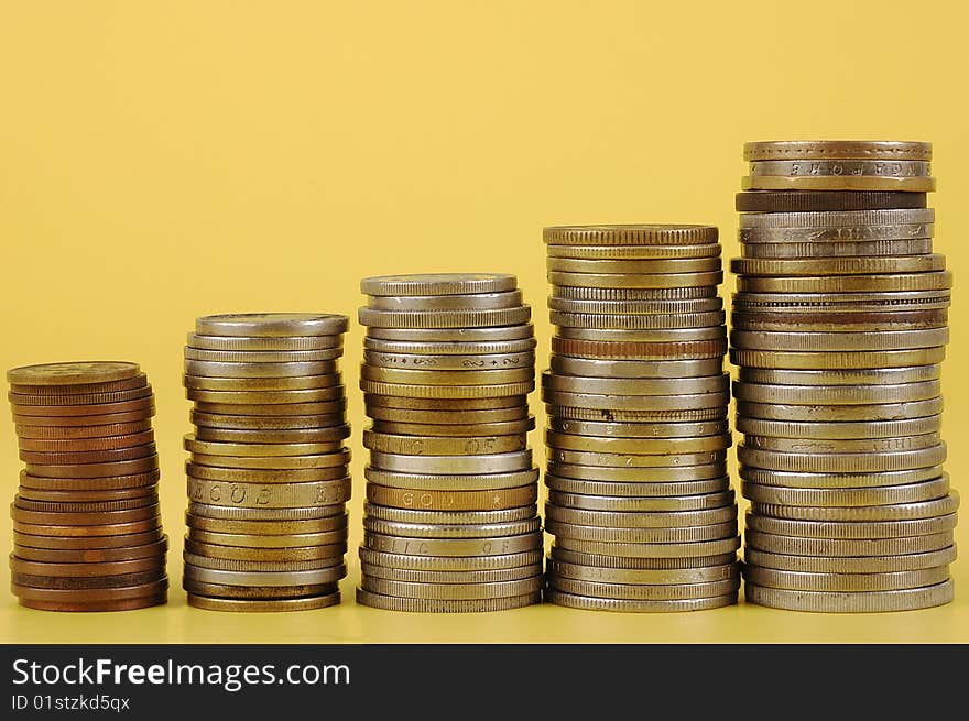 Foreign coins on yellow background