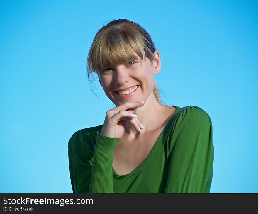 Portrait of the young woman posing on a background of the dark blue sky. Portrait of the young woman posing on a background of the dark blue sky