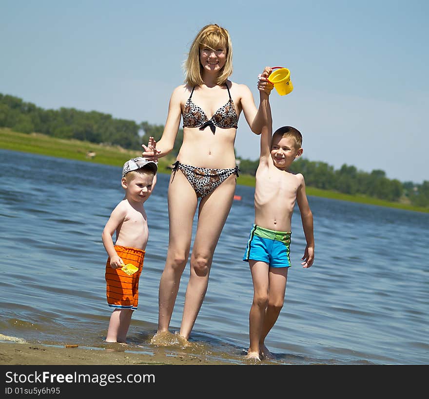 Young mum plays with two sons on the nature. Young mum plays with two sons on the nature