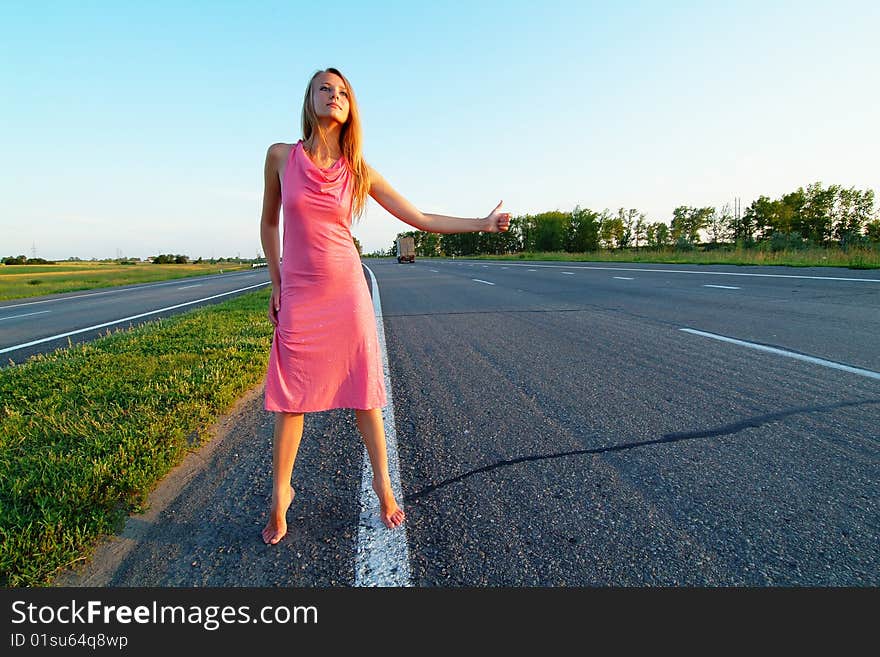 The woman running on road against the sunset sun