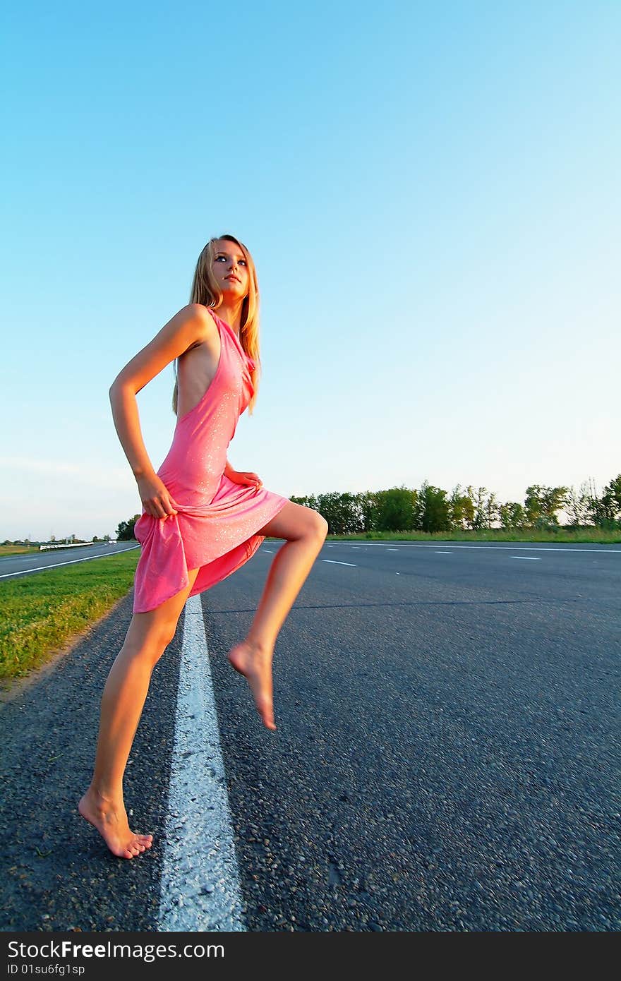 The woman running on road against the sunset sun