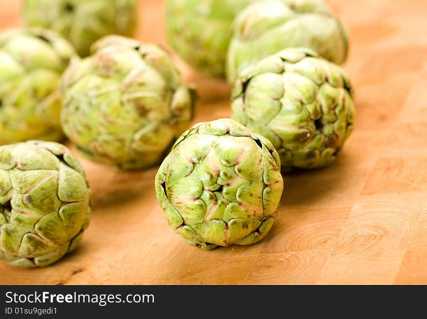 Baby Artichokes on wooden cutting board