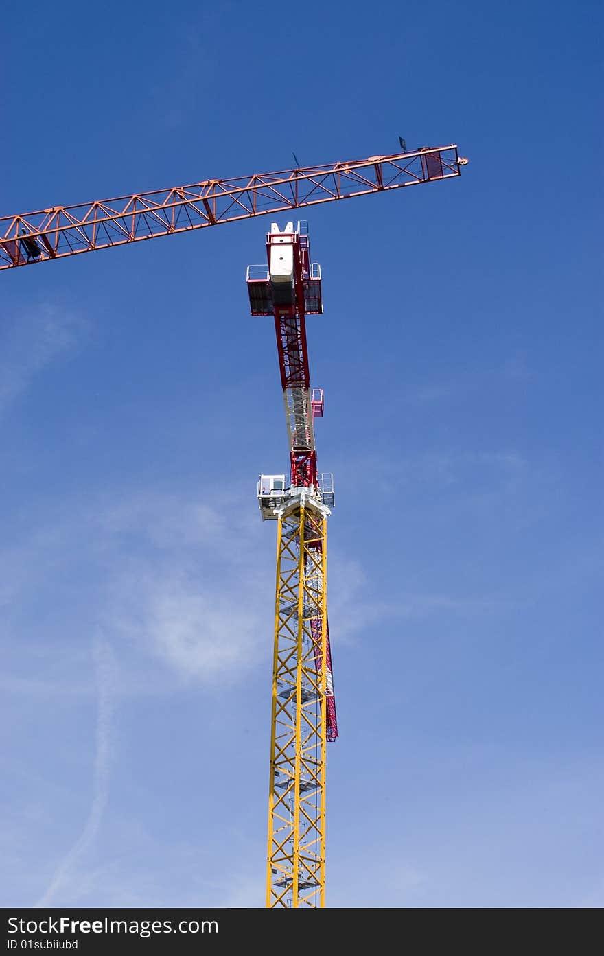 Two construction cranes on a blue sky