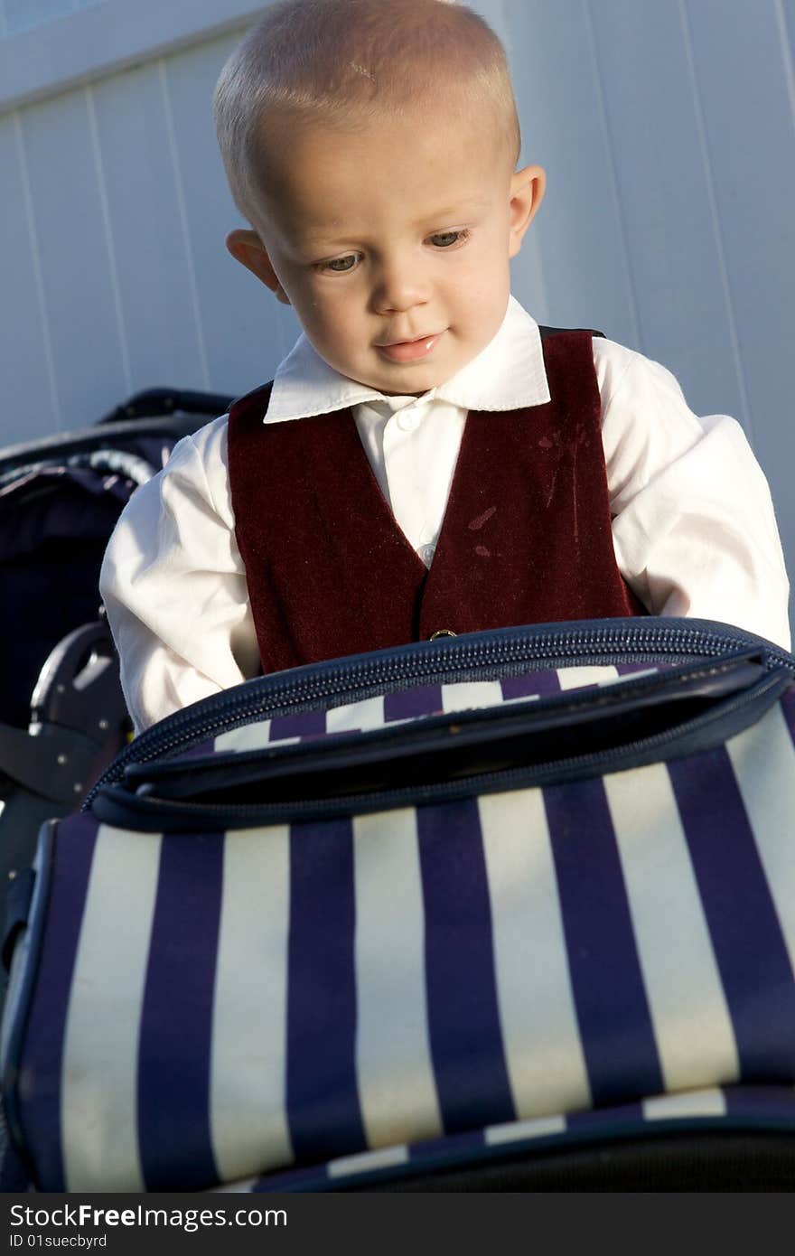 A fascinated little boy looking at a suitcase