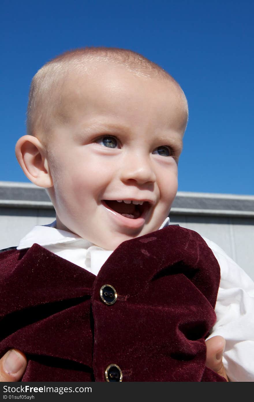 An interested little boy with big blue eyes and a bald head