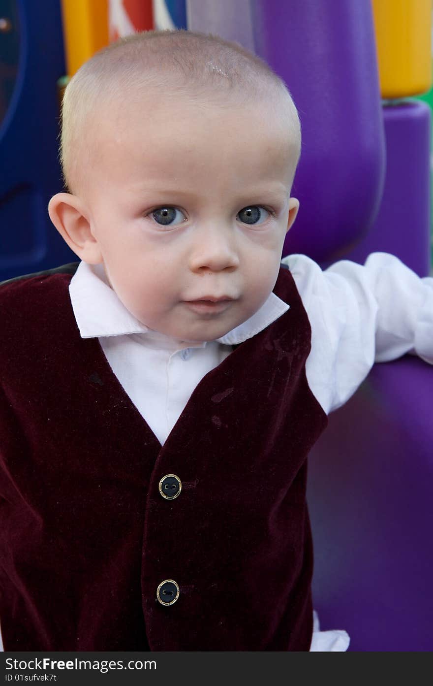 An interested little boy with big blue eyes and a bald head