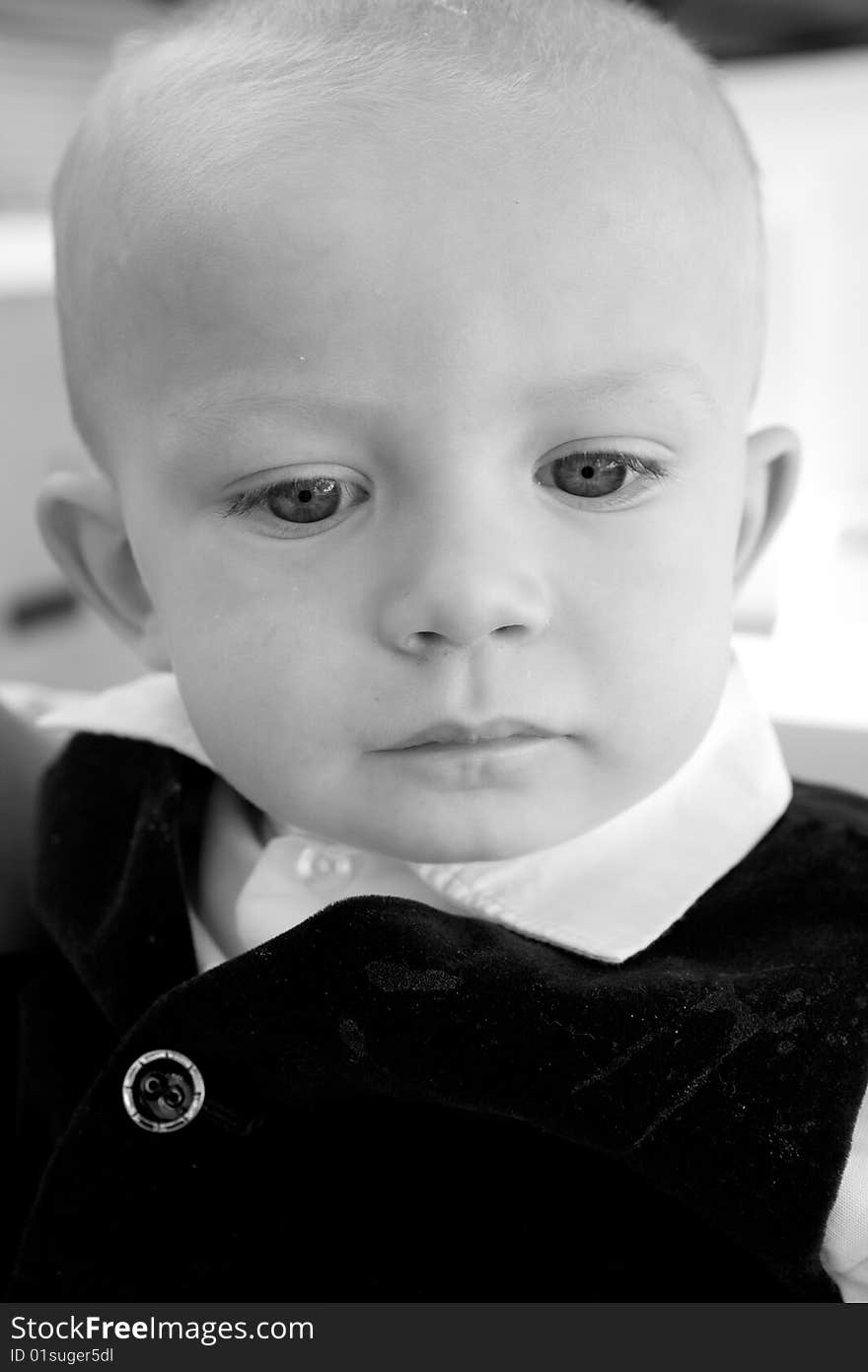 An deep thinking little boy with big blue eyes and and bald head