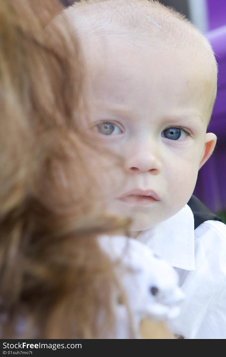 An interested little boy with big blue eyes and a bald head