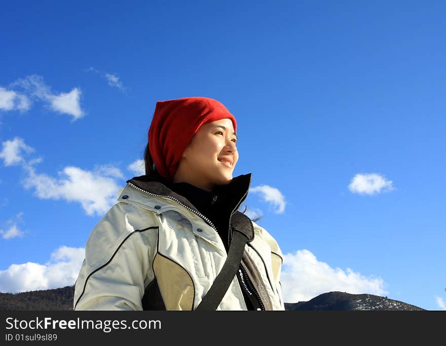 Woman hiker stands and enjoying the sunshine.