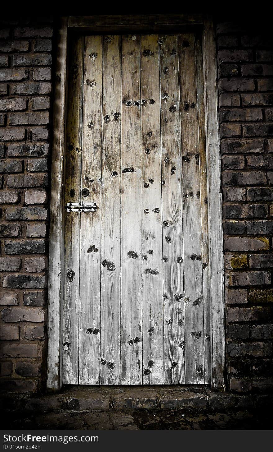 A locked wood door in brick wall. A locked wood door in brick wall