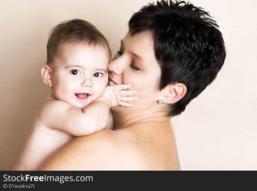 Beautiful brunette mother holding her cute baby. Beautiful brunette mother holding her cute baby