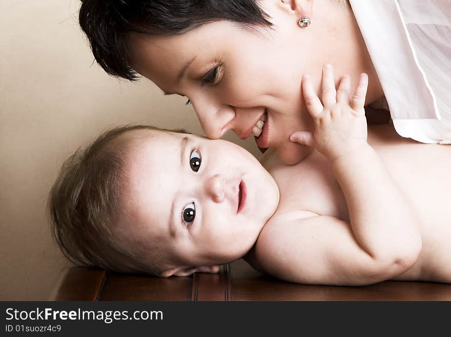 Beautiful brunette mother holding her cute baby. Beautiful brunette mother holding her cute baby