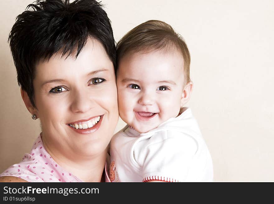 Beautiful brunette mother holding her cute baby. Beautiful brunette mother holding her cute baby