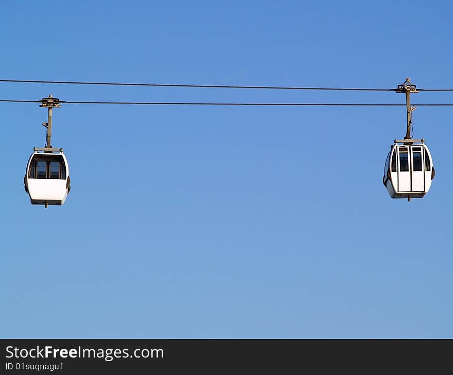 Two cable car cabins set against a blus sky, lisbon, portugal. Two cable car cabins set against a blus sky, lisbon, portugal