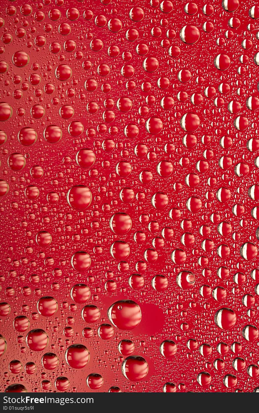 Water droplets on red background