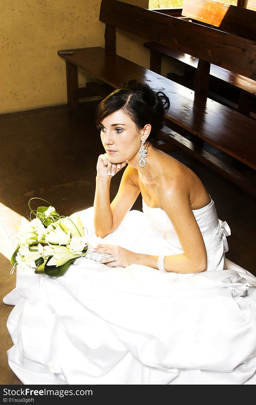 Beautiful brunette bride sitting on a step in the chapel. Beautiful brunette bride sitting on a step in the chapel