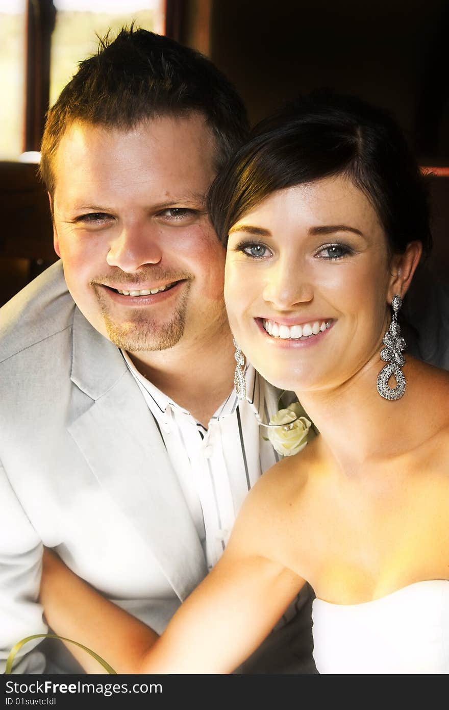 Beautiful brunette bride sitting by her groom. Beautiful brunette bride sitting by her groom