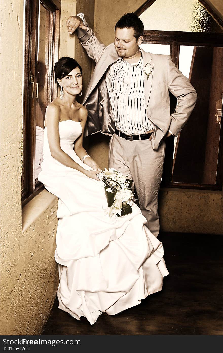 Beautiful brunette bride sitting by her groom. Beautiful brunette bride sitting by her groom