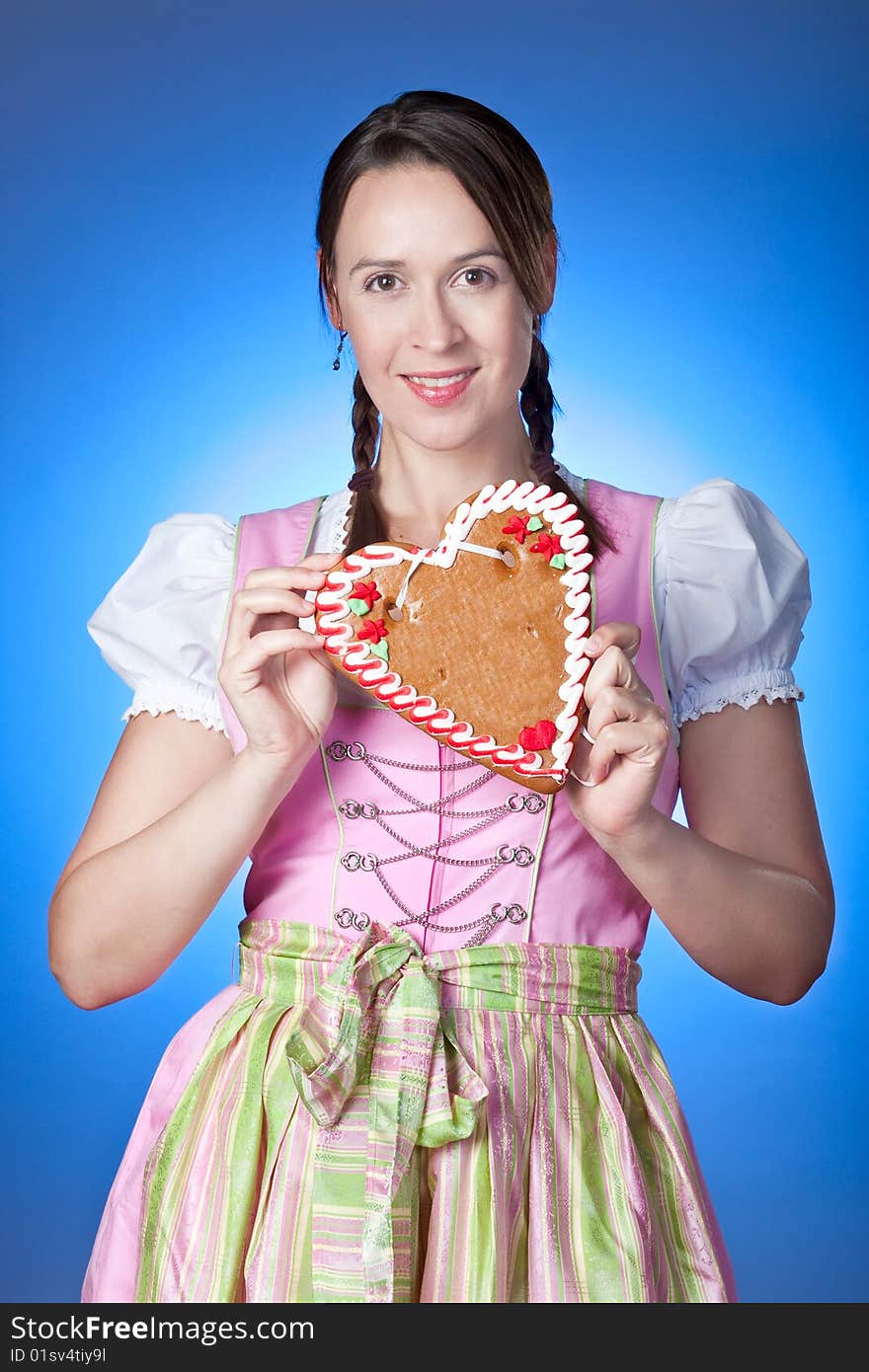 A young Oktoberfest girl in a Dirndl and a traditional gingerbread Herzl. A young Oktoberfest girl in a Dirndl and a traditional gingerbread Herzl.