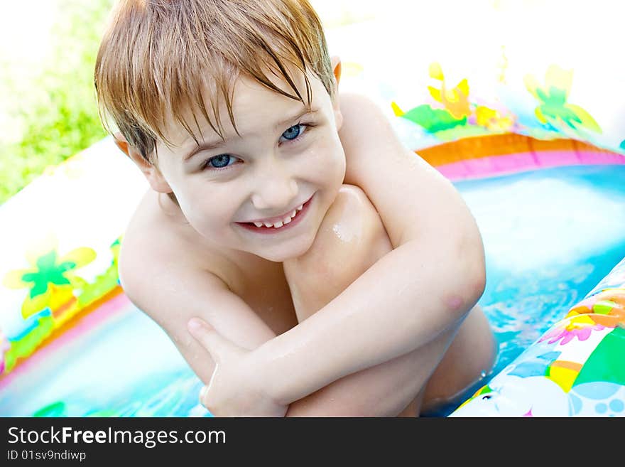 The boy bathes in inflatable pool