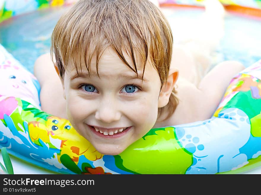 The boy bathes in inflatable pool